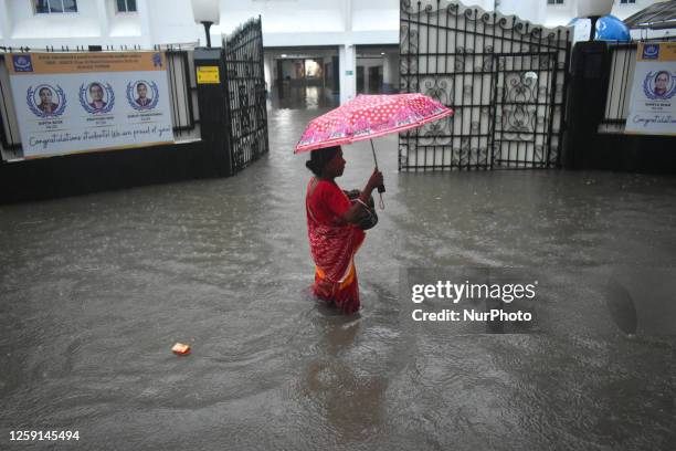 Woman is walking in a waterlogged street after heavy rain in Kolkata, India on 28 June 2023.