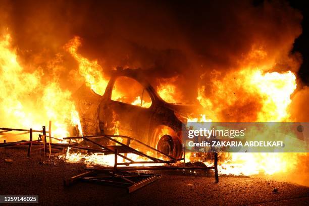 Vehicle burns, destroyed by protesters in Nanterre, west of Paris, on June 27 after French police killed a teenager who refused to stop for a traffic...