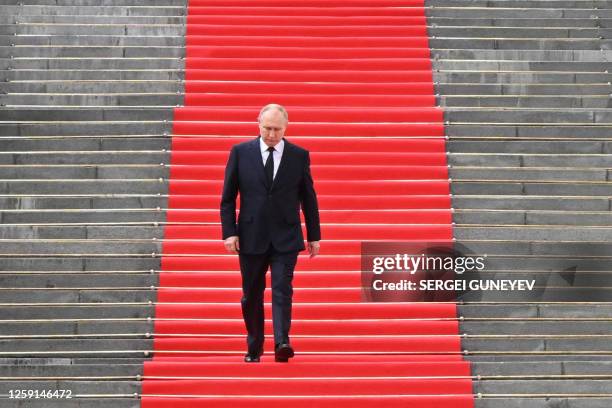 Russian President Vladimir Putin walks down the steps to address troops from the defence ministry, National Guard, FSB security service and interior...