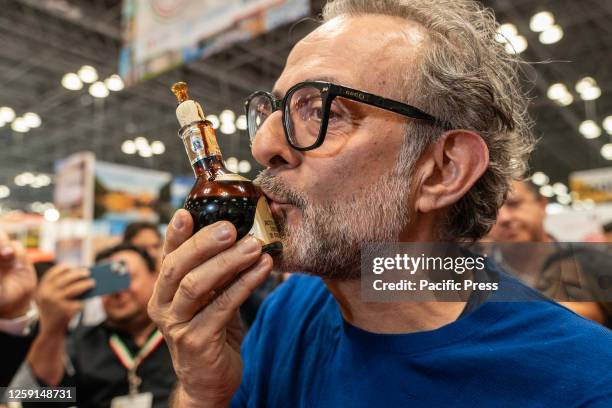 Micheline 3-star chef Massimo Bottura kisses bottle of Modena balsamic vinegar during presentation at Emilia-Romagna booth at Summer Fancy Food Show...