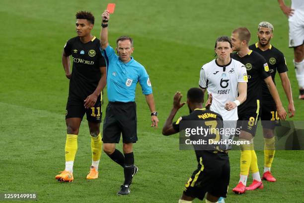 Match referee Keith Stroud shows a red card to Rico Henry of Brentford during the Sky Bet Championship Play Off Semi-final 1st Leg match between...