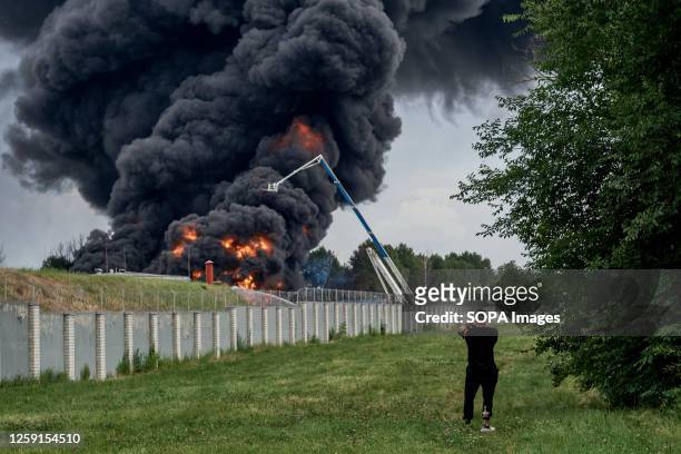 Local resident filming the fire at the Oil Depot. A fuel tank was burning at an oil depot in Voronezh, where a hundred firefighters are working to...