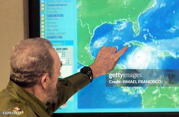 Cuban President Fidel Castro explains on an electronic display of the map of the Caribbean the possible trajectories of Hurrican Ivan as it...