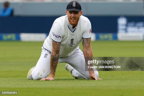 England's captain Ben Stokes reacts after failing to stop a ball on day one of the second Ashes cricket Test match between England and Australia at...