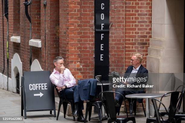 Two businessmen take an afternoon coffee break on Telegraph Street in the City of London, the capital's financial district, on 27th June 2023, in...