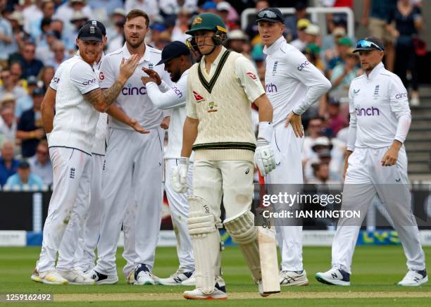 England's captain Ben Stokes and England's Ollie Robinson celebrates taking the wicket of Australia's Marnus Labuschagne for 47 runs on day one of...