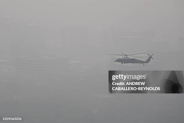 In this aerial view, Marine One with US President Joe Biden flies over a hazy Chicago, Illinois, on June 28, 2023. Some 80 million people from the...