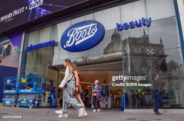 People walk past the Boots store in Piccadilly Circus as the pharmacy and beauty products chain announces it will close 300 shops.