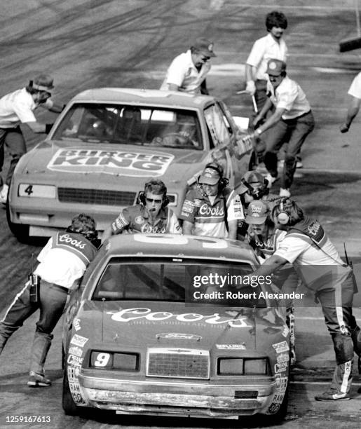 Driver Bill Elliott prepares to leave a pit stop, followed by driver Lennie Pond, during the running of the 1984 Daytona 500 stock car race at...