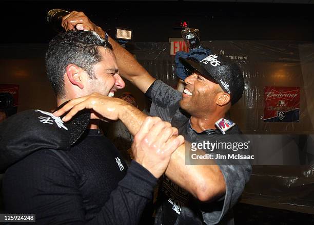 Jorge Posada and Mariano Rivera of the New York Yankees celebrate after clinching the American League East division against the Tampa Bay Rays on...