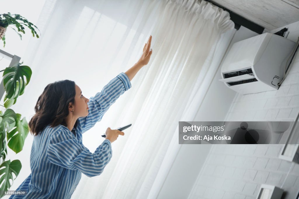 Turning on the air conditioner.