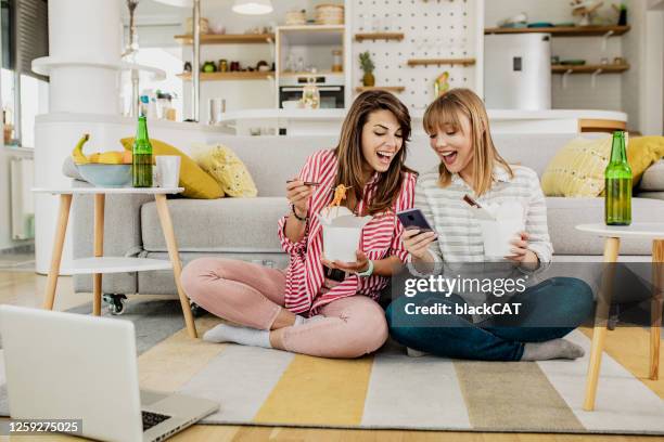 2人の女性の友人がパスタに家で食べるように命じた - cat food ストックフォトと画像