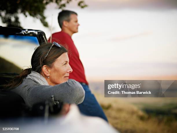 mature couple watching sunset - married car stock pictures, royalty-free photos & images