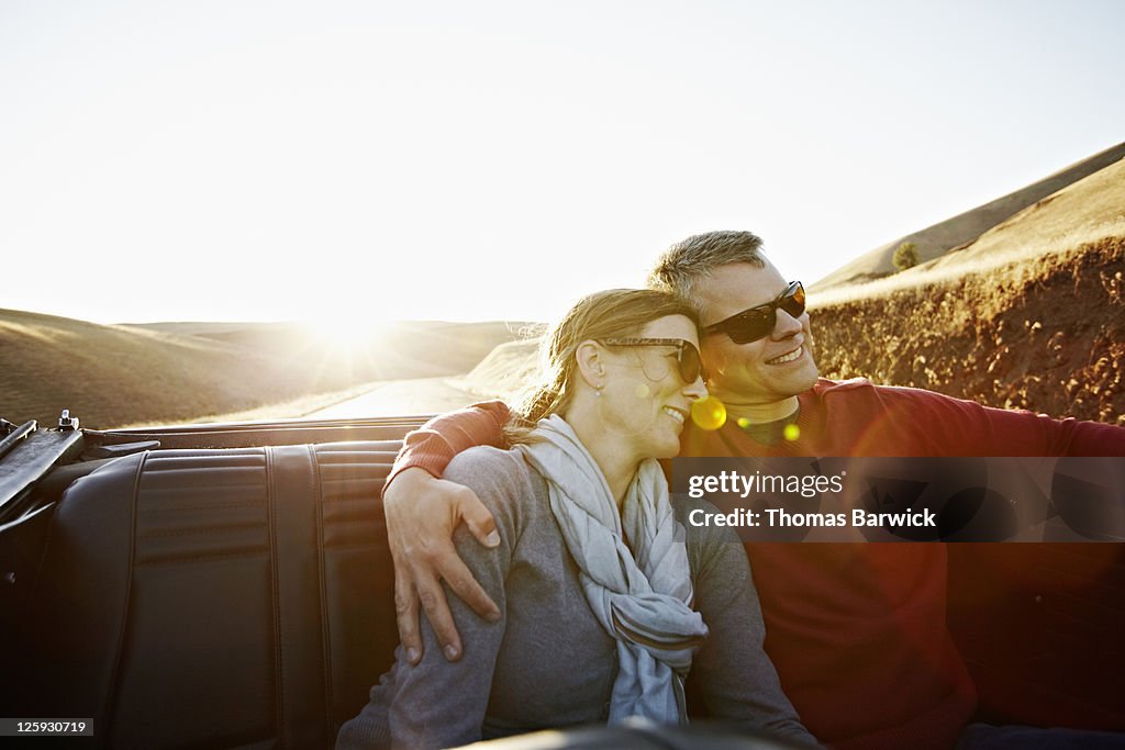 Husband and wife in the backseat of convertible