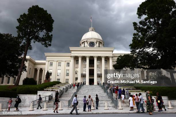 People make their way up the Alabama State Capitol past archival posters of civil rights icon, former US Rep. John Lewis on July 26, 2020 in...