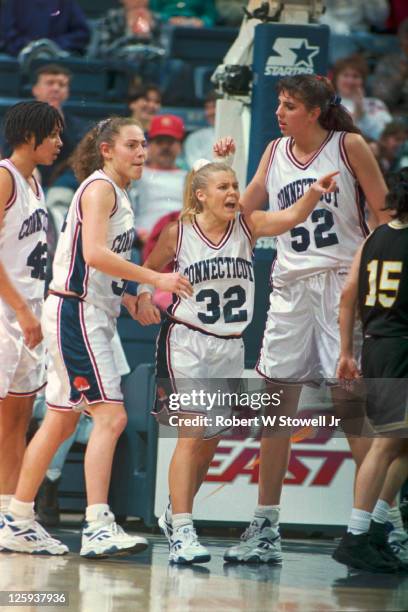 University of Connecticut's basketball player Pam Webber, number 32, gestures with emotion as teammates Carla Berube and Kara Wolters stand beside...