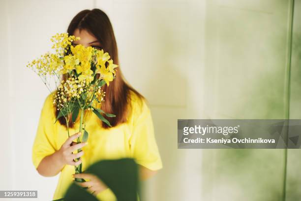 child girl holding bouquet of yellow flowers. - giving a girl head fotografías e imágenes de stock