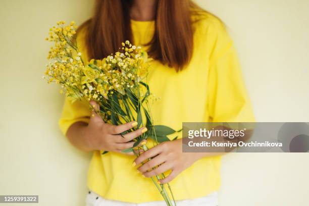 child girl holding bouquet of yellow flowers - giving a girl head stock pictures, royalty-free photos & images