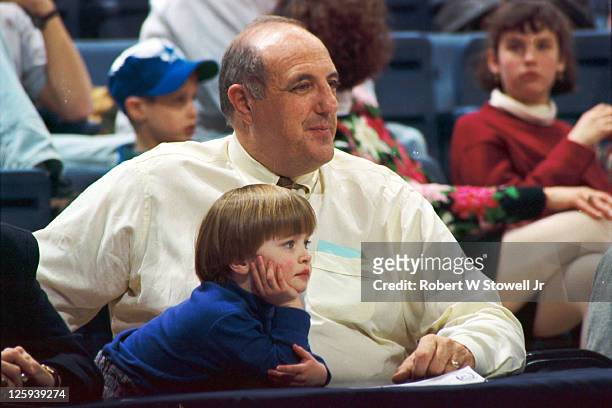 University of Connecticut Athletics Director Lew Perkins sits courtside with his granddaughter Caroline during a women's basketball game at Gampel...