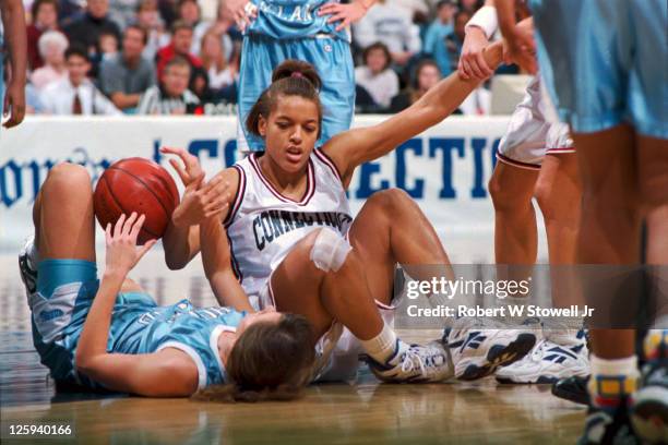 University of Connecticut player Kim Better is helped up by a teammate after fighting for a loose ball, during a game at Gampel Pavilion in Storrs,...