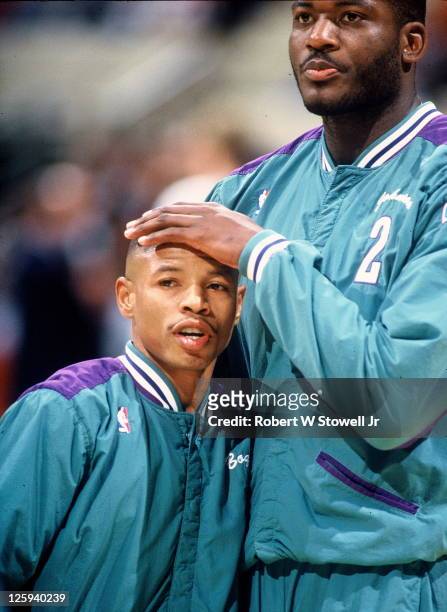 Charlotte Hornets duo of point guard Tyrone 'Mugsy' Bogues and forward Larry Johnson embrace during pregame introductions for a game against the...