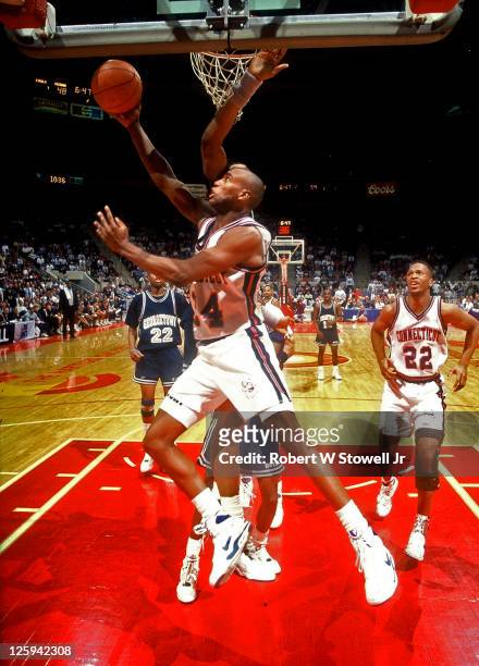 University of Connecticut player Scott Burrell goes in for a reverse lay-up against Big East rival Georgetown, Hartford CT, 1990.