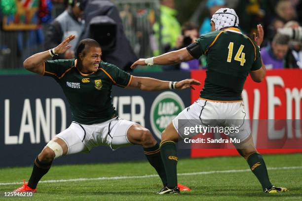 Juan de Jongh of South Africa celebrates scoring a try with Gio Aplon during the IRB 2011 Rugby World Cup Pool B match between South Africa and...