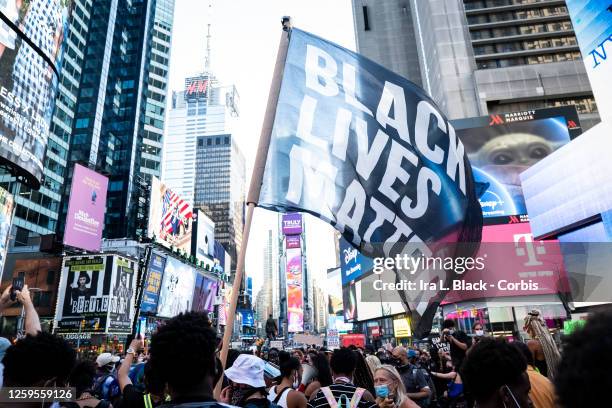 July 26: A protester holds a large flag that says, "Black Lives Matter" which is draping the landscape of Times Square in New York. This non-violent...