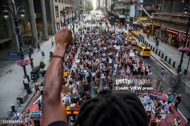 Man raises his arm in support of the crowd of protesters marching in downtown New York, NY on July 26, 2020. Hundreds of New York activists...