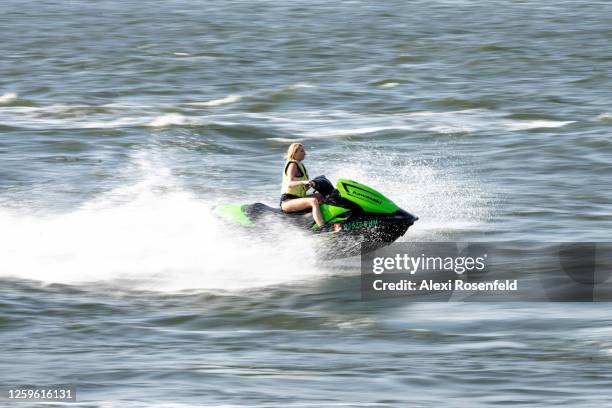 Woman is seen riding a Kawasaki jet-ski on the East River as the city continues Phase 4 of re-opening following restrictions imposed to slow the...