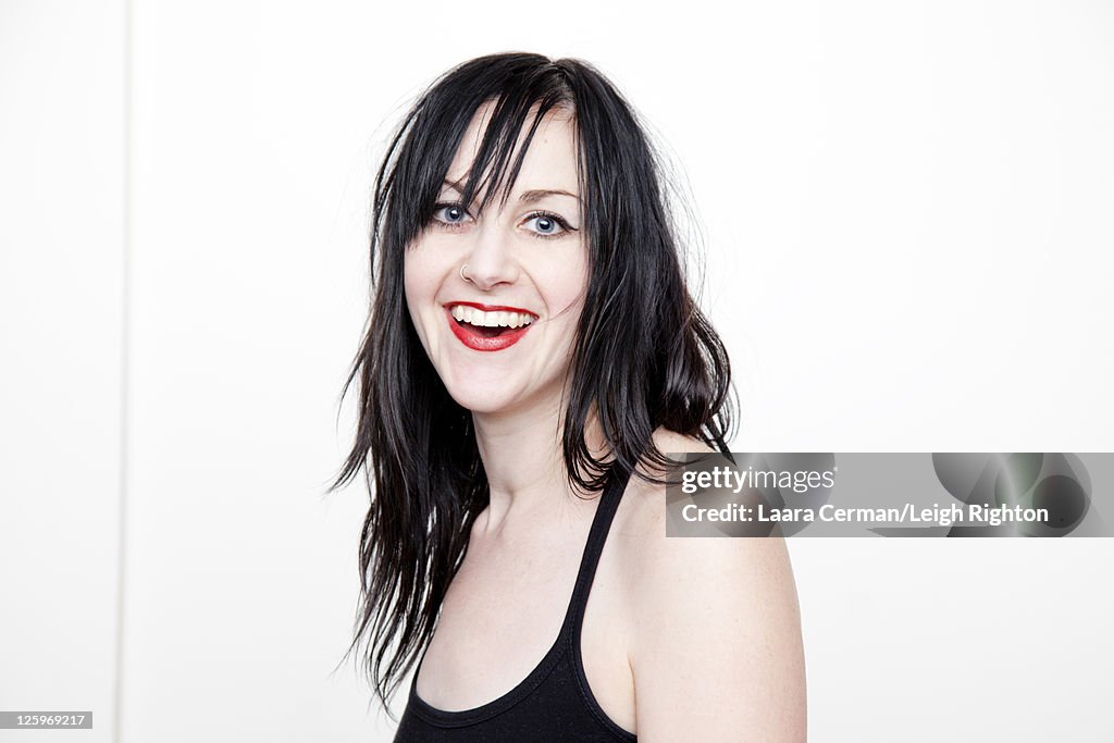 Portrait of a Caucasian woman (28 years old) smiling in front of a white background