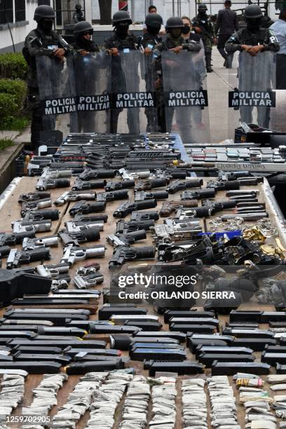 Members of the Military Police of Public Order display weapons, ammunition, drugs, mobile phones and other items seized to imprisoned members of the...