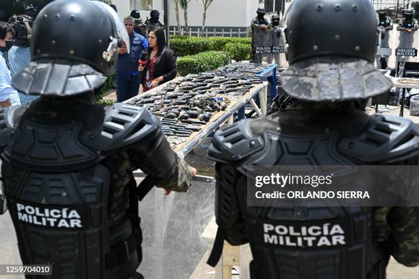 Members of the Military Police of Public Order display weapons, ammunition, drugs, mobile phones and other items seized to imprisoned members of the...