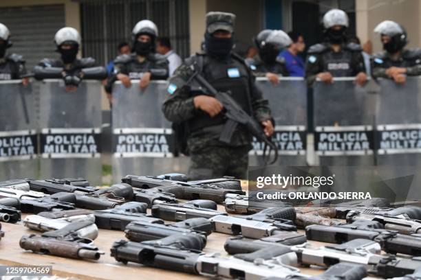 Members of the Military Police of Public Order display weapons, ammunition, drugs, mobile phones and other items seized to imprisoned members of the...