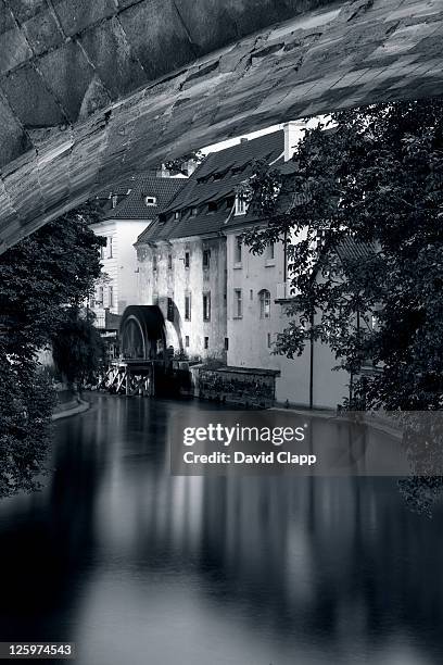 vltava river underneath charles bridge, looking towards an old water wheel, prague, czechoslovakia, czech republic, europe - water wheel stock pictures, royalty-free photos & images