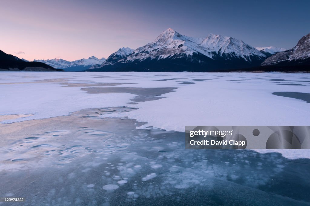 Cracked ice on frozen glacial lake, looking towards Elliot Peak on Abraham Lake, Canadian Rockies, Alberta, Canada