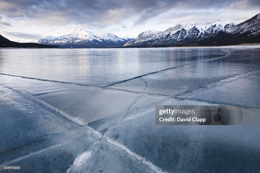 Cracked ice on frozen glacial lake, Abraham Lake, Canadian Rockies, Alberta, Canada