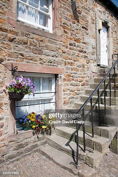 hanging baskets outside the hark to bounty inn at slaidburn in the forest of bowland, lancashire, england, uk - flower basket stock pictures, royalty-free photos & images