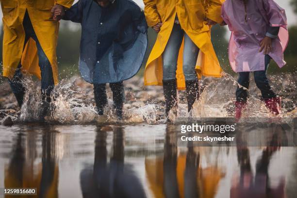 unrecognizable carefree family having fun while stepping into water. - spring flowing water stock pictures, royalty-free photos & images