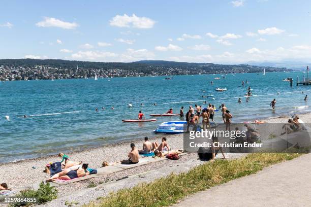 People relax on a Sunday at Lake Zurich during the coronavirus pandemic on July 12, 2020 in Zurich, Switzerland. Switzerland has largely lifted most...