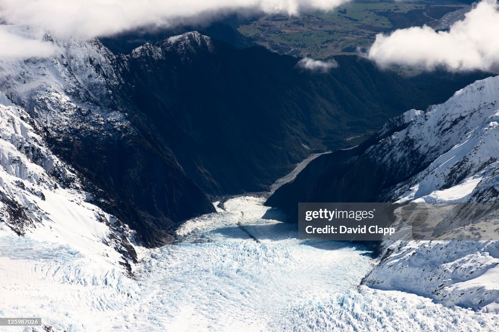 View directly down Fox Glacier, millions of tons of ice slowly cascade down from peaks of the Southern Alps and terminate within the sub-tropical rainforests of the South Island's West Coast, Mount Cook National Park, Southern Alps, South Island, New Zeala