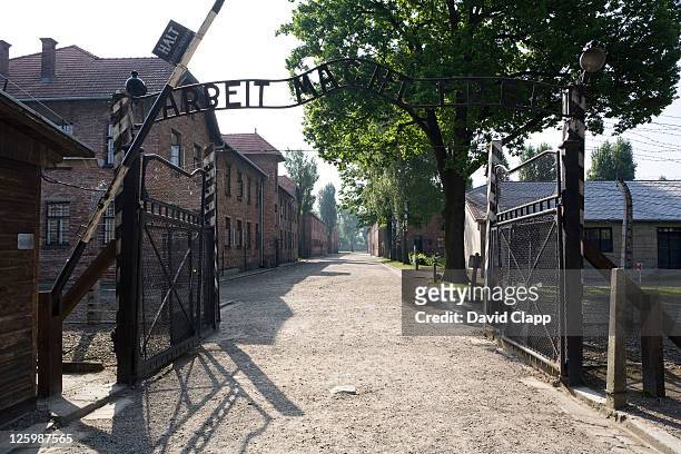 entrance gateway into auschwitz i, arbeit macht frei - 'work sets you free' at auschwitz concentration camp, poland - auschwitz stock pictures, royalty-free photos & images