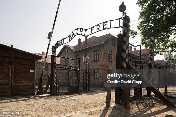entrance gateway into auschwitz i, arbeit macht frei - 'work sets you free' at auschwitz concentration camp, poland - auschwitz stockfoto's en -beelden