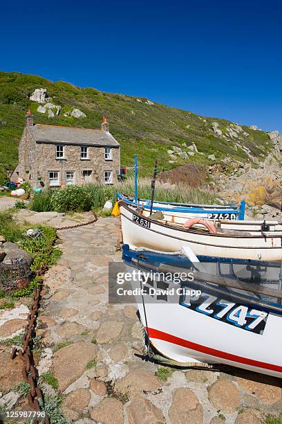 traditional cottage and crab potting boats moored near water's edge at penberth, cornwall, england - lands end cornwall stock pictures, royalty-free photos & images