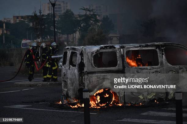 Firefighters extinguish a burning vehicle during clashes in Toulouse, southwestern France on June 28 a day after the killing of a 17 year old boy in...