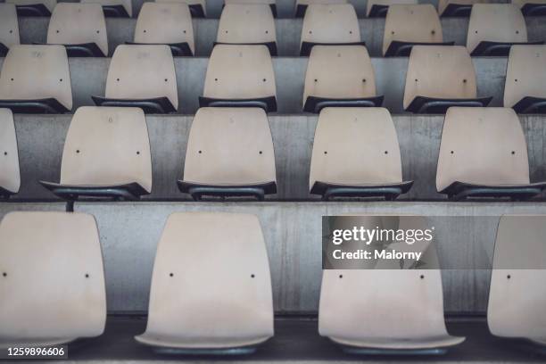 numerous rows of stadium seats. - white bench stock pictures, royalty-free photos & images