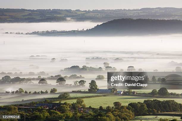 layers of mist and fog across somerset levels at glastonbury, somerset, england, uk - glastonbury somerset stock-fotos und bilder