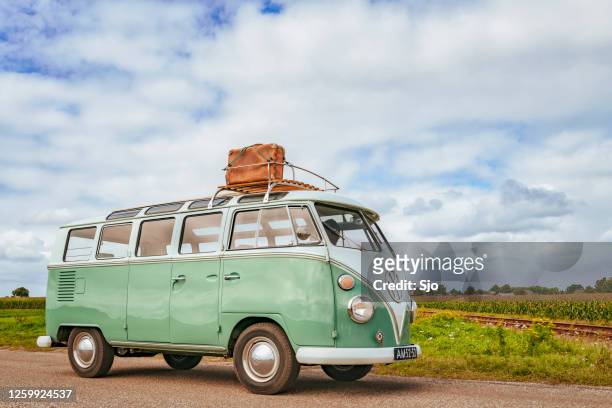 volkswagen bus type 2 t1 camper van driving through the countryside - volkswagen stock pictures, royalty-free photos & images