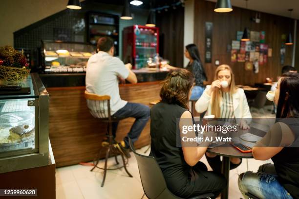 people in a small coffee shop - small restaurant stock pictures, royalty-free photos & images