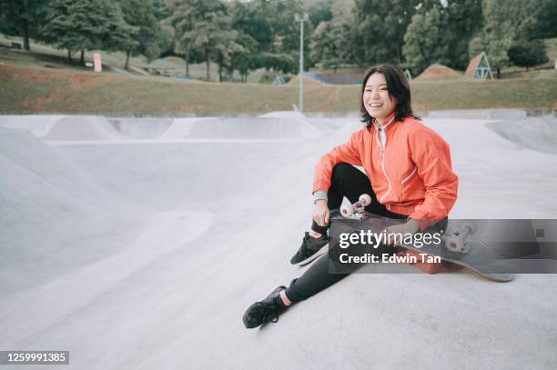 a young chinese girl practising skateboarding in the public skateboarding park during weekend - extreme skating stock pictures, royalty-free photos & images